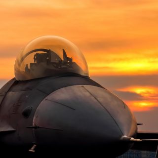 f16 falcon fighter jet on sunset  background
